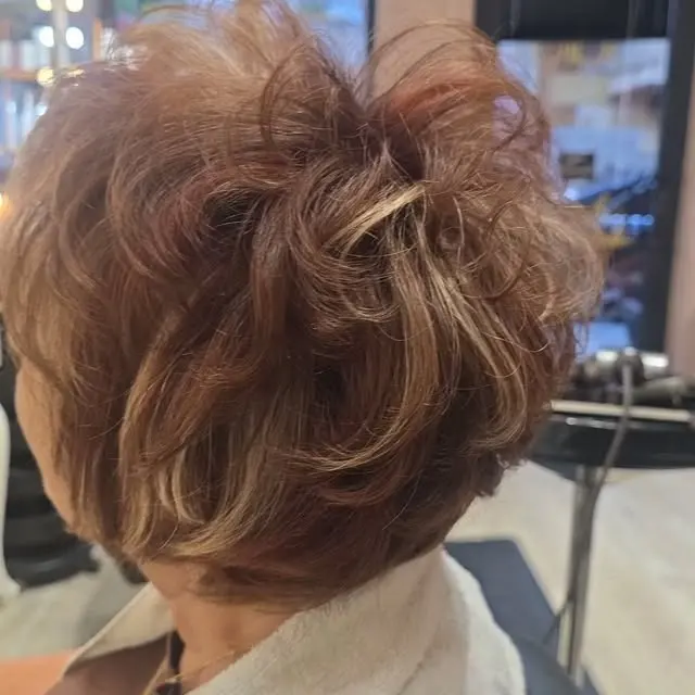A short layered cut in copper brown with blonde lights